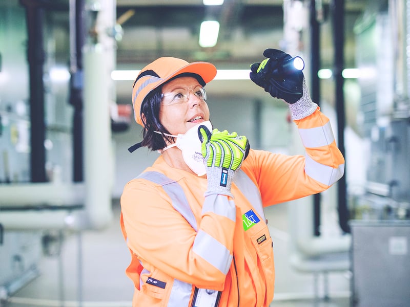 Kiinteistotekniikan työntekijä osoittaa taskulampulla