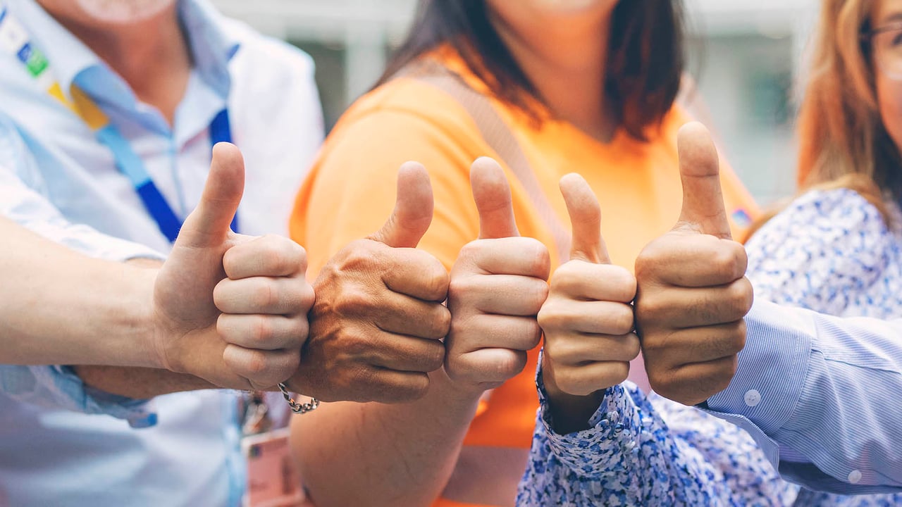 Työntekijät näyttävät peukkua kameralle