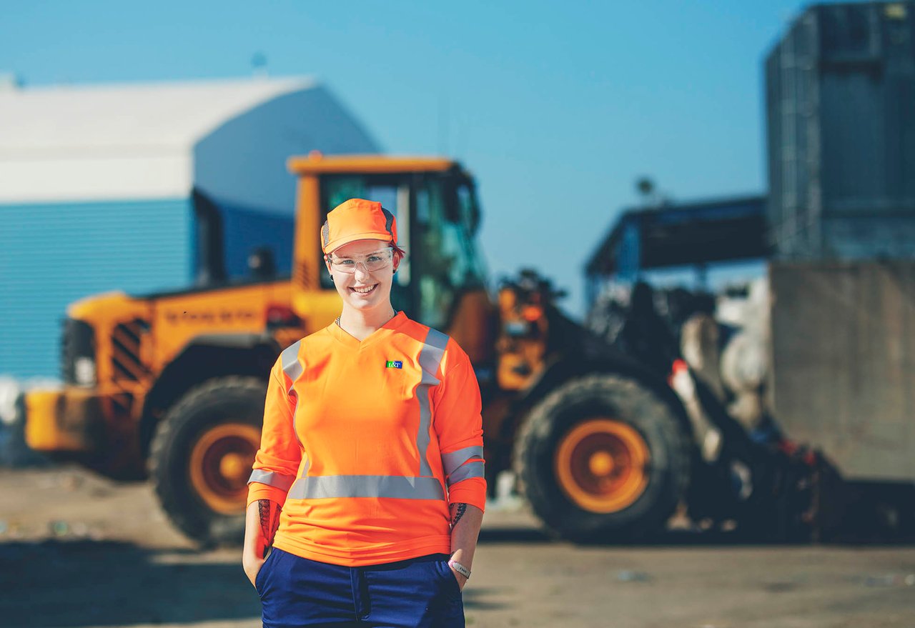 Kierrätyslaitoksen työntekijä hymyilee