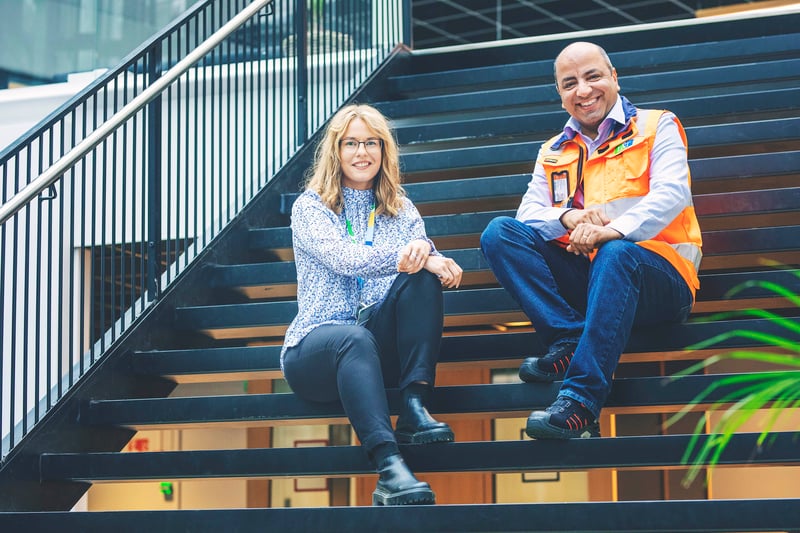 Mies ja nainen istuvat portailla hymyillen