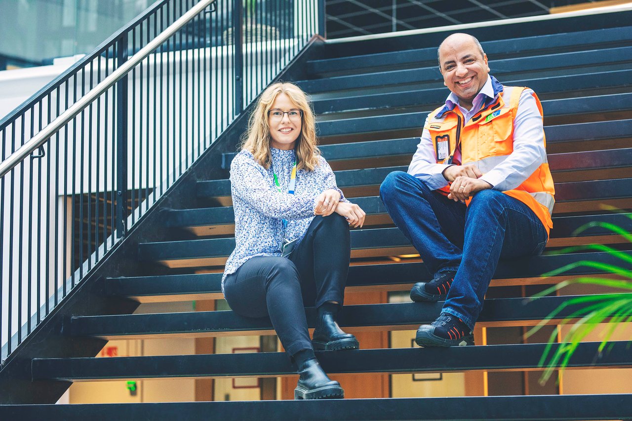 Mies ja nainen istuvat portailla hymyillen