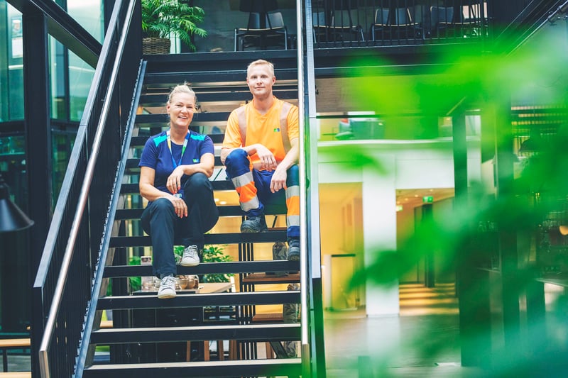 Siivooja ja kiinteistöhoitaja istuvat portailla