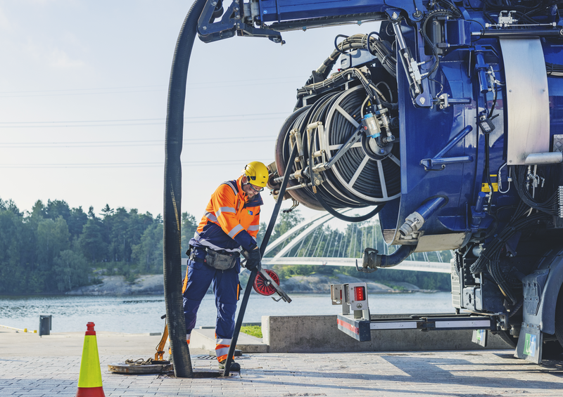 Kuva viemäriautosta ja työntekijästä